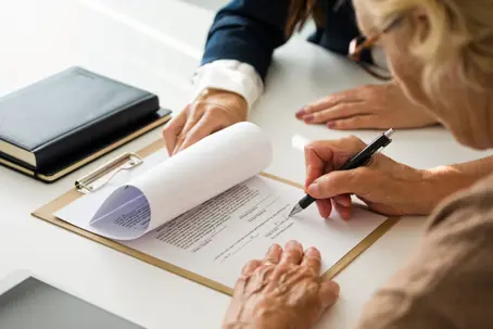 Female lawyer explaining the will to senior woman. Close up of hands, unrecognizable people.